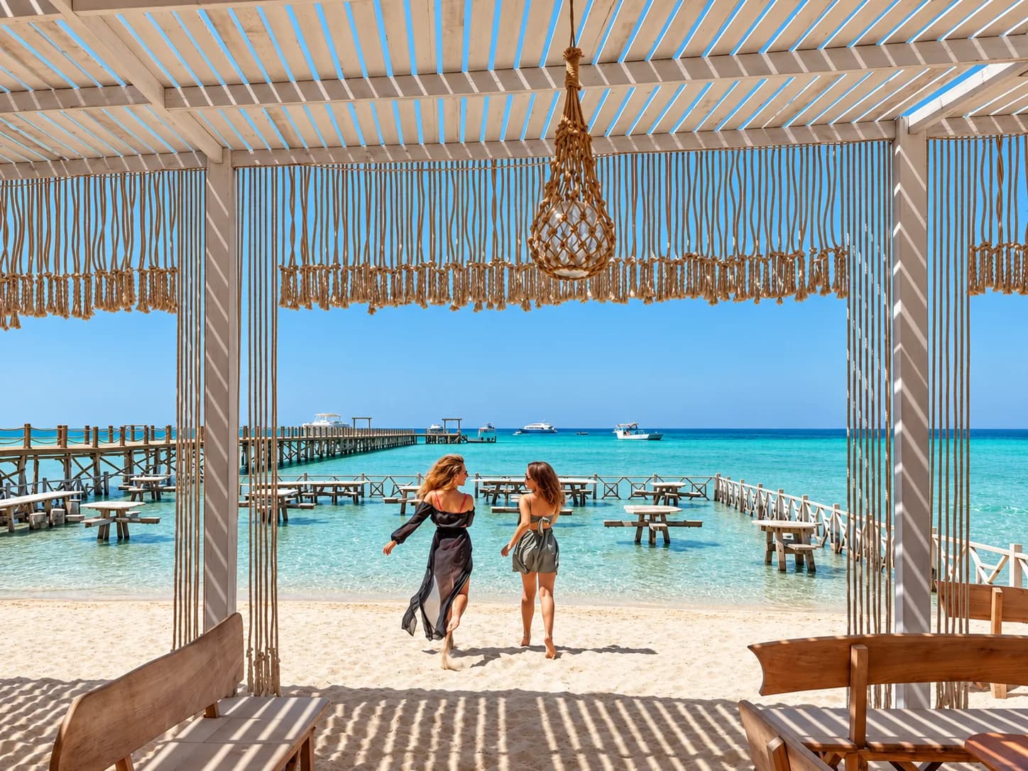 Guests walking toward a turquoise Red Sea island pier
