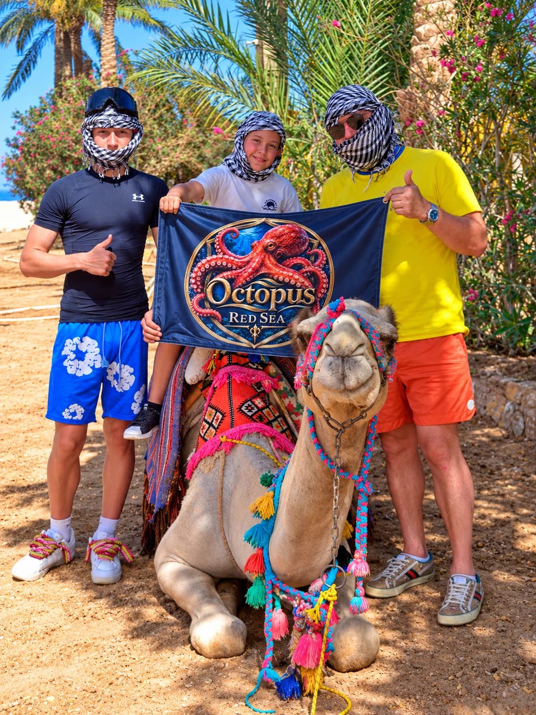 Travel group posing beside a camel and a blue Octopus Red Sea branded banner